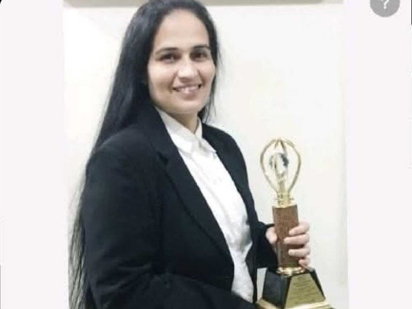 Dr Krupa Torne holding an award for Best Women Achiever in Pediatric Neurology